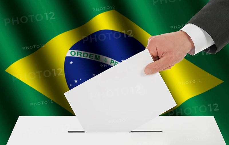 The Brazilian flag and the hand with the bulletin about the ballot box