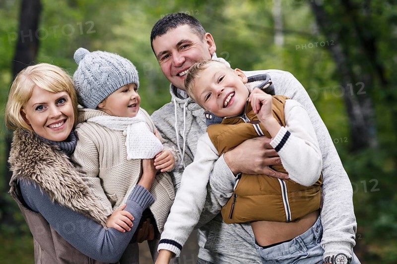 Close up portrait of a young family in the autumn park