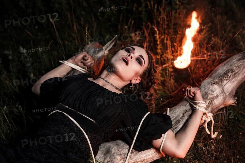 Beautiful young witch in the flames of fire