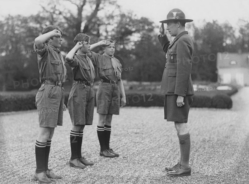 Folke Bernadotte, 1895-1948, leader of the swedish scouts movement saluting three boy scouts in the traditional salute way doing the Scout promise. Baden-Powell introduced the Scout Promise, as follows: (1) Before he becomes a scout, a boy must take the scout's oath, thus: 'On my honour I promise that— I will do my duty to God and the King. I will do my best to help others, whatever it costs me. I know the scout law, and will obey it.' While taking this oath the scout will stand, holding his right hand raised level with his shoulder, palm to the front, thumb resting on the nail of the little finger and the other three fingers upright, pointing upwards: This is the scout's salute and secret sign