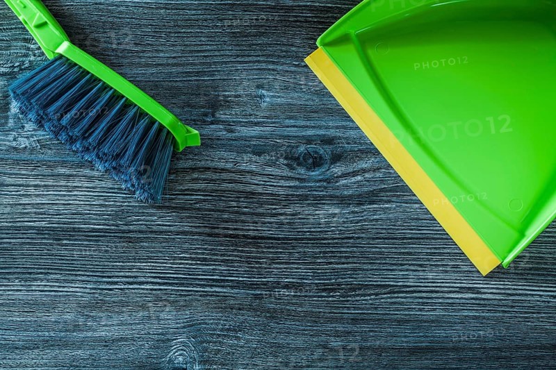 Dustpan and garbage broom set on wooden board