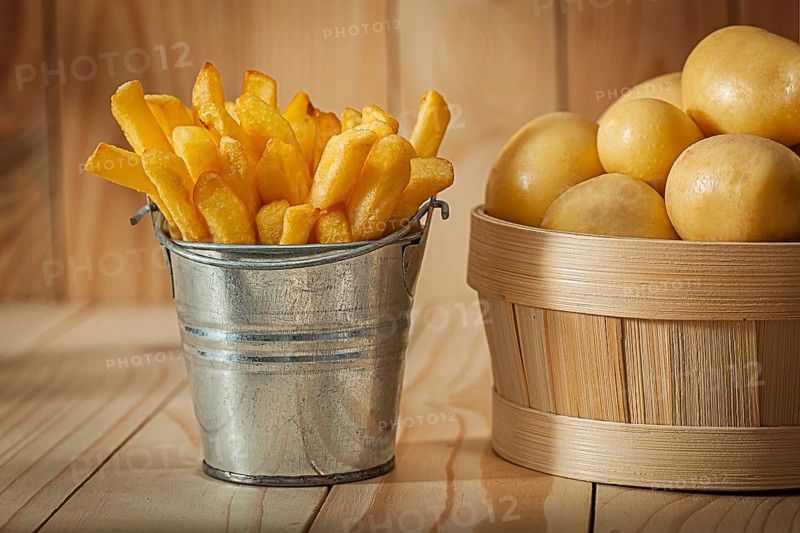 Potato Fries And Whole Potato On Wood Background