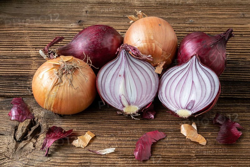 Yellow and red onions on a wooden board