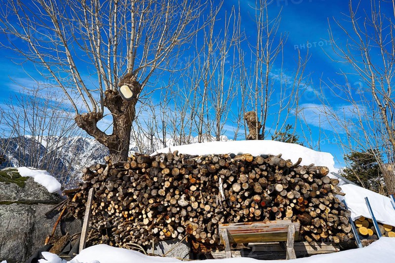 Firewood stacked under snow in Pyrenees of Huesca Spain