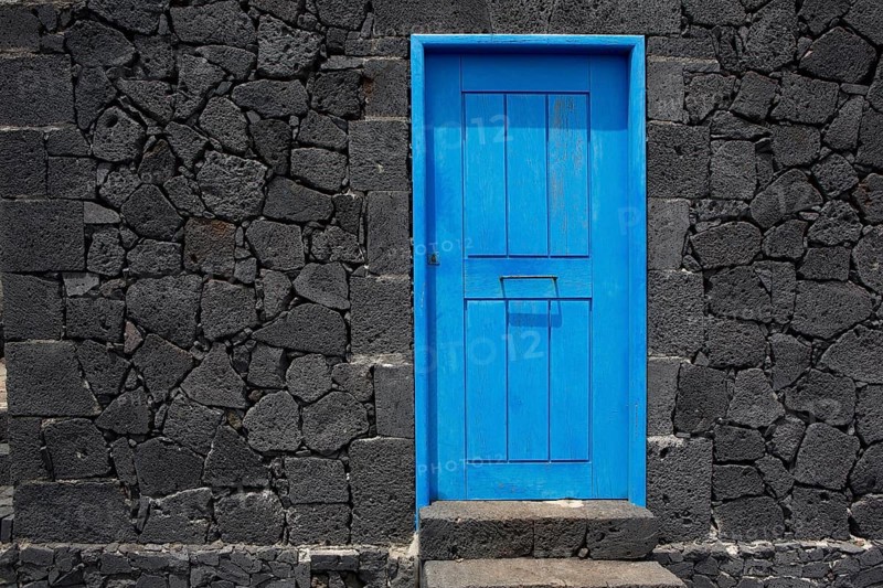Blue door in black lava stone masonry wall at La Palma Canary Islands