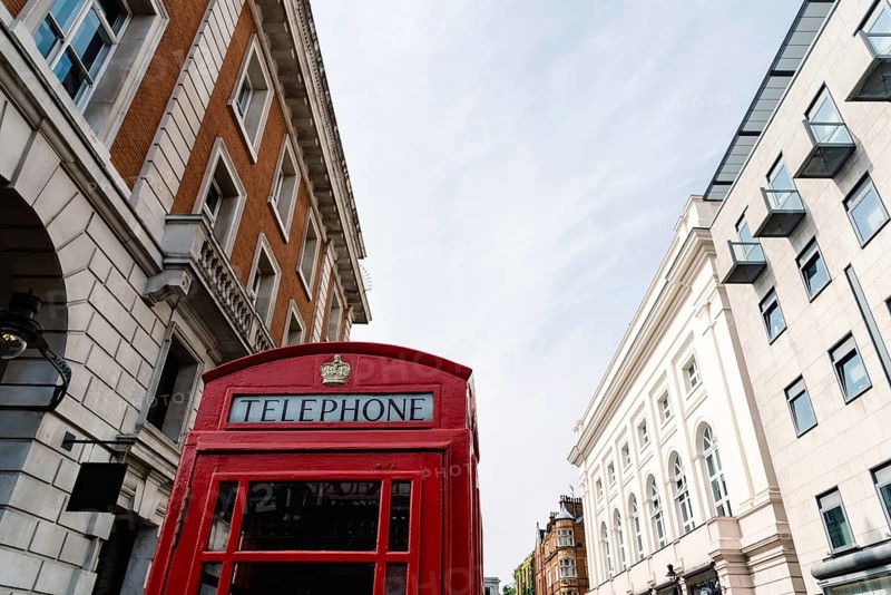 Traditional red telephone box in London, England, UK. Low angle view against sky in Covent Garden area