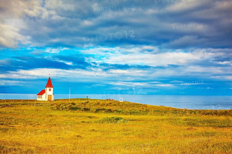 Iceland. White Chapel with red roof on the northern fjord