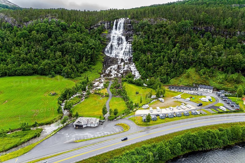 The colossal roaring waterfall Twindefossen. Rainy summer day in the mountains of Norway. Exciting adventure in the north of Norway. Travel north. The photo was taken from a drone