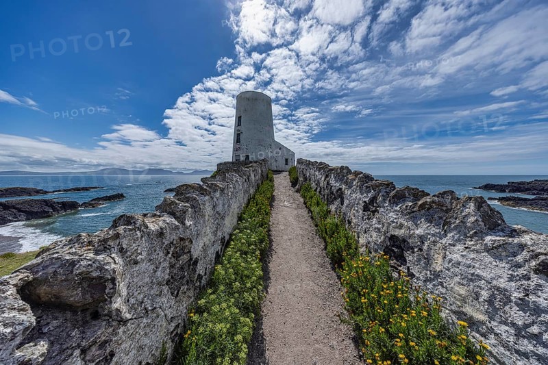Twr Mawr Lighthouse, white lighthouse by the sea with blue sky and clouds, Ynys Llanddwyn, Newborough, Anglesey, Wales, Great Britain