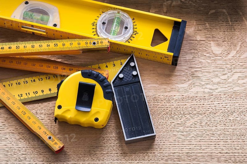 Oaken board with wooden meter measuring line construction level and square ruler maintenance concept