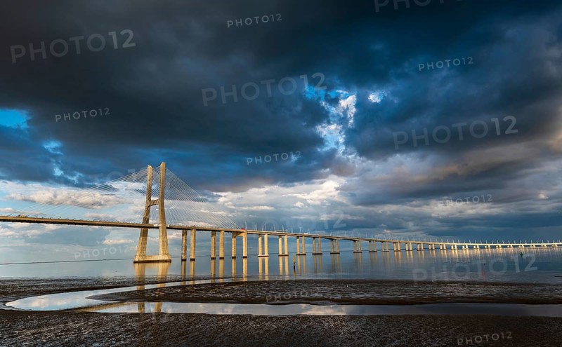 Vasco da Gama Bridge at sunset with dramatic cloudy blue sky in Lisbon, Portugal, Europe
