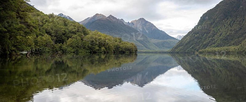 Tranquil lake Gunn in Fiordland National Park, landscape reflecting on the water surface, South Island of New Zealand