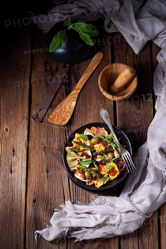 Pasta salad with green asparagus, olives and Parma ham