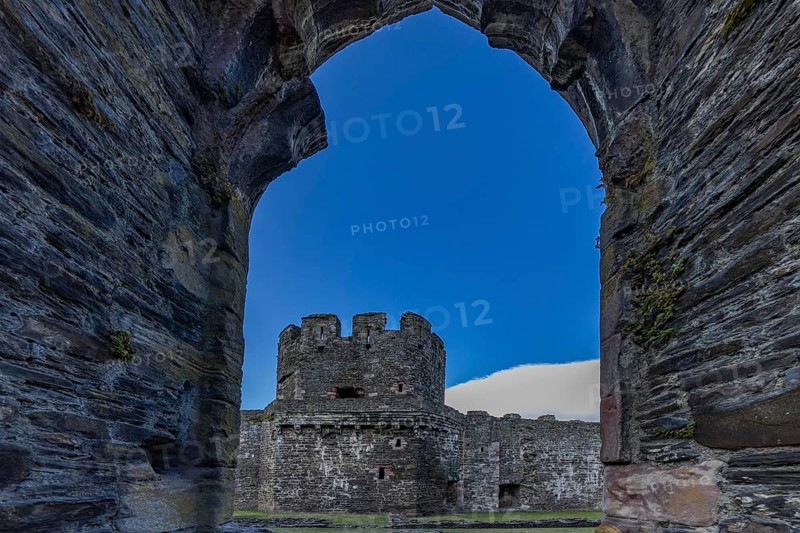 Conwy Castle, view through an arched opening in the castle wall to the tower of the medieval castle with blue sky, Conwy, Wales, Great Britain