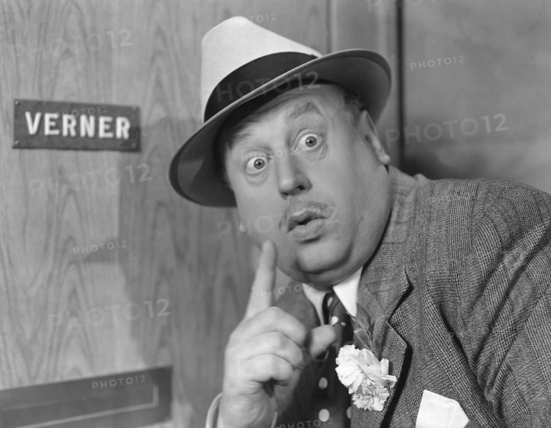 Secretive in the 1940s. Actor Thor Modéen pictured while acting in the movie Tåget går klockan 9. Making the sign with his finger, perhaps to silence someone and to be able to listen to what they are saying on the other side of the door he stands in front of. Sweden 1941