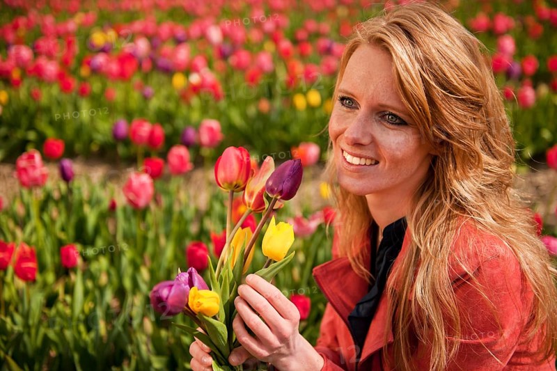 Portrait of a beautiful blond Dutch girl in tulips field