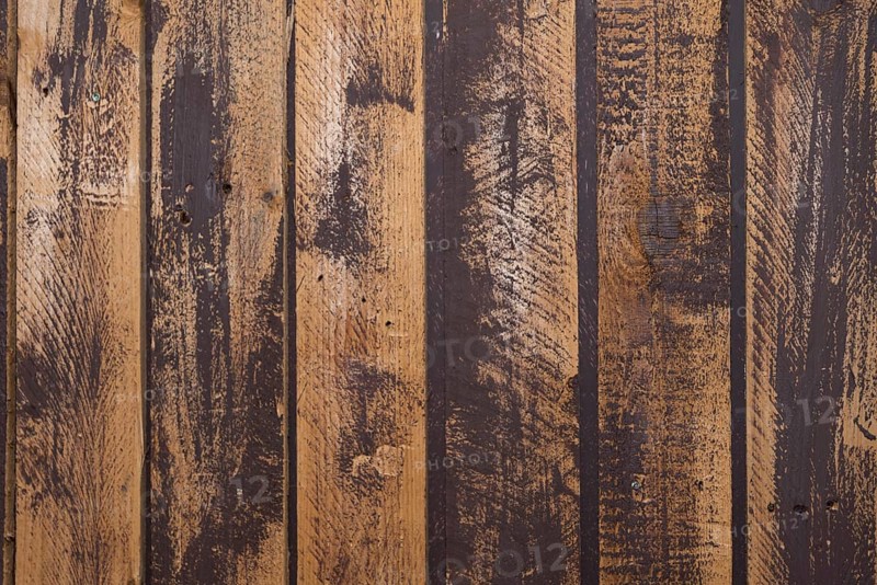 Unevenly painted dark wooden wall, uneven colour on the boards