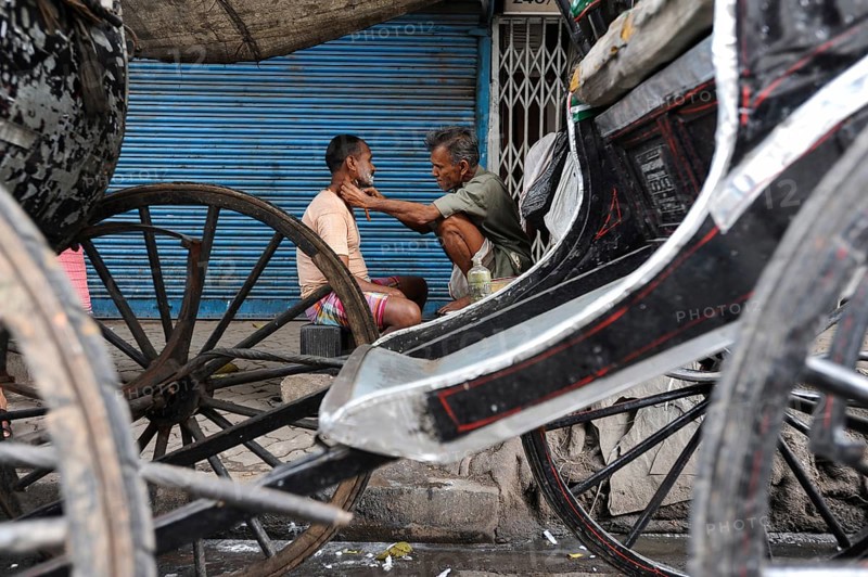 20.02.2011, Kolkata, West Bengal, India, Asia, A man gets a shave between rickshaws on a roadside in Kolkata, the only city in India where hand-pulled rickshaws still exist, Asia