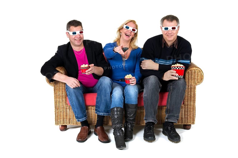 Three persons are laughing about the 3D movie on televison