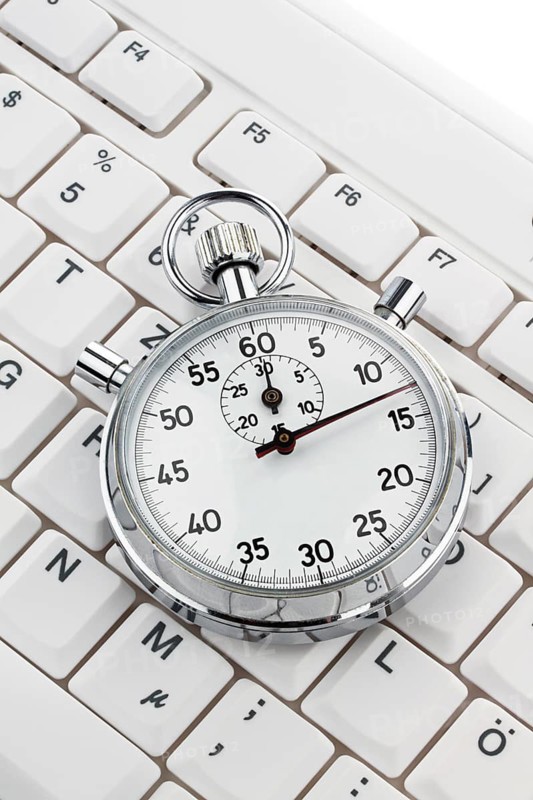 A stopwatch lies on a computer keyboard. Working time is money Austria