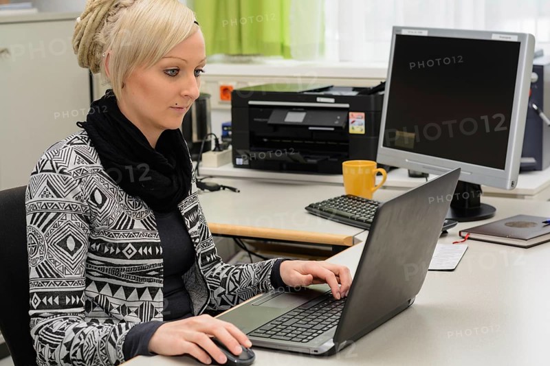 Young office clerk works in the office at a computer workstation