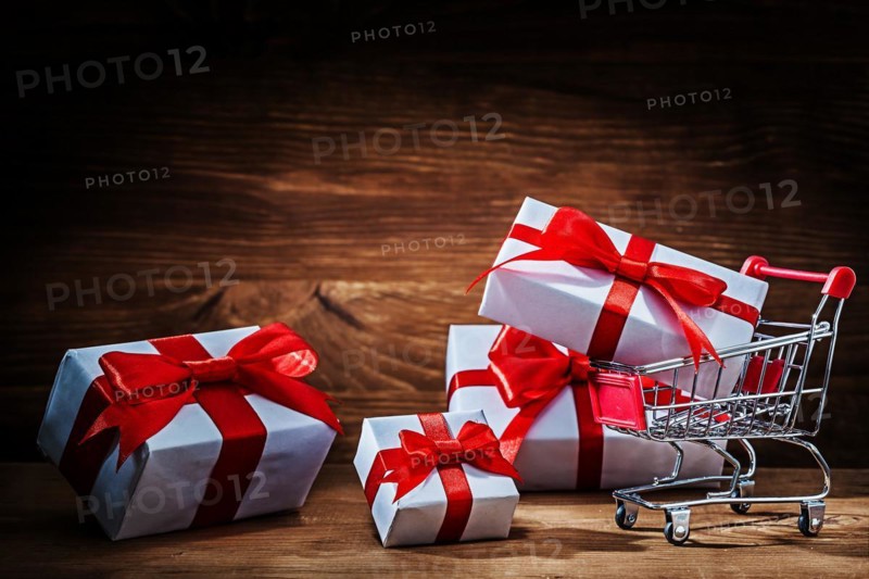 Set of white gift boxes with shopping trolley on vintage wood