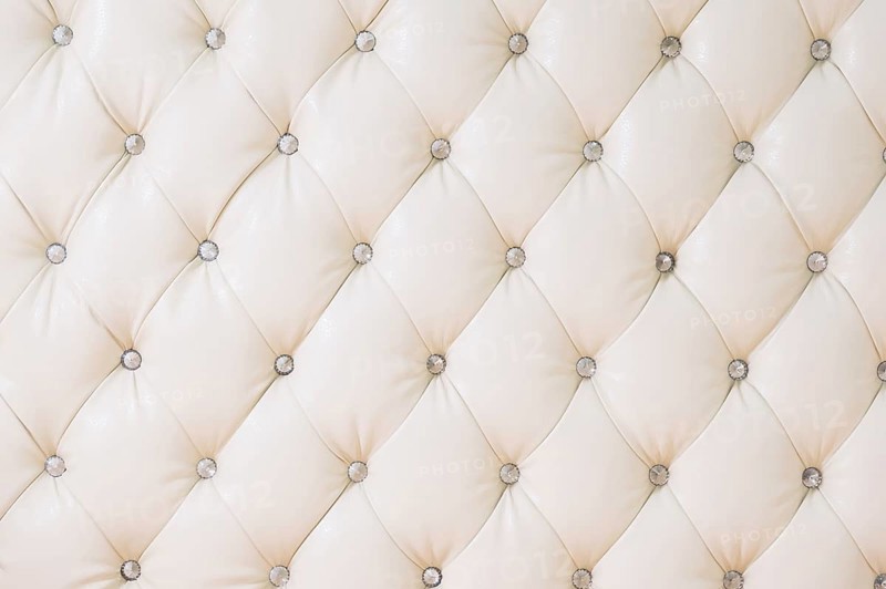 Beige soft tapestry pattern background with symmetrical buttons on the corners of diamonds. Soft and expensive furniture elements. Luxury background