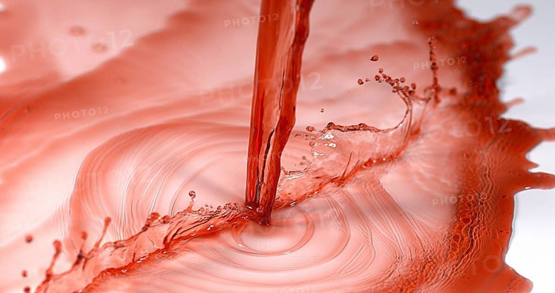 Red Wine being poured against White Background