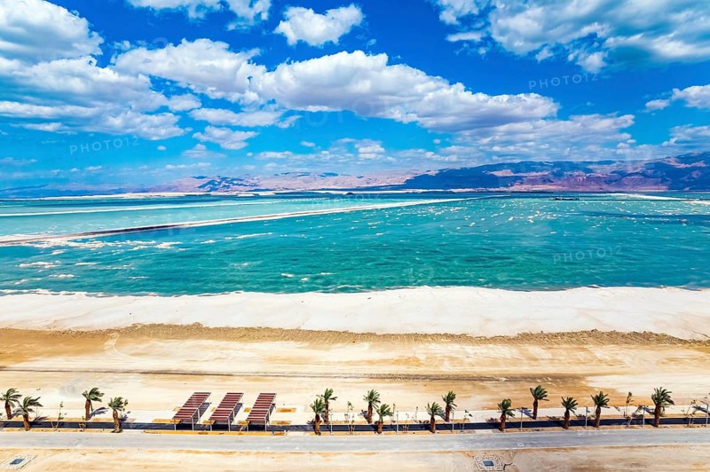 The Dead Sea is an endorheic salt lake. Israel. Magnificent resort for treatment and relaxation. Drone filming. The picturesque embankment is lined with palm trees