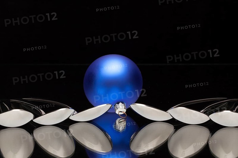 Blue Christmas decoration and six spoons on a black glass desk