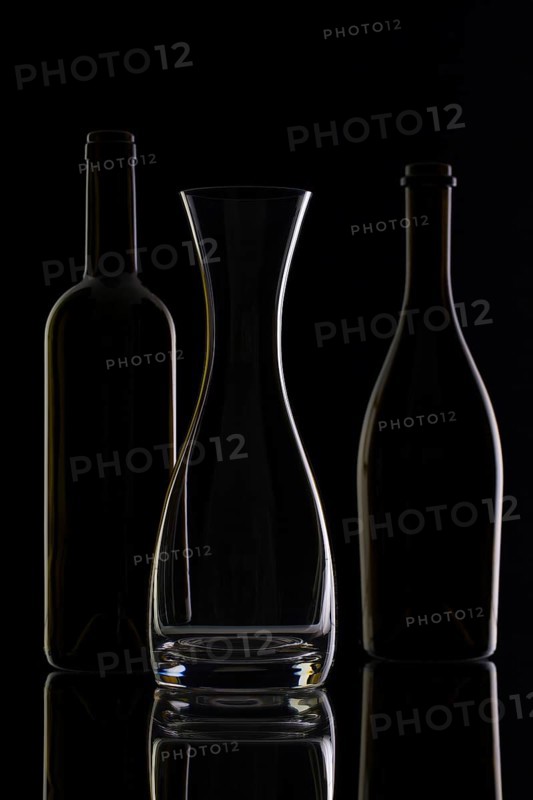Empty glass and bottles on the black background