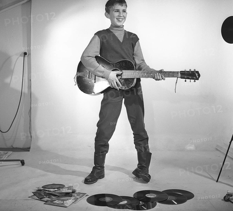 Boy in the 1950s. A boy is photographed in a studio and plays the guitar, perhaps with the Rock n' roll artists of the time in mind. Sweden 1959 Kristoffersson ref CF62