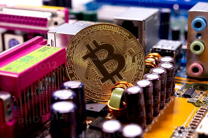 Virtual cryptocurrency money Bitcoin golden coin on a computer printed circuit board PCB. The future of money. Computational equipment