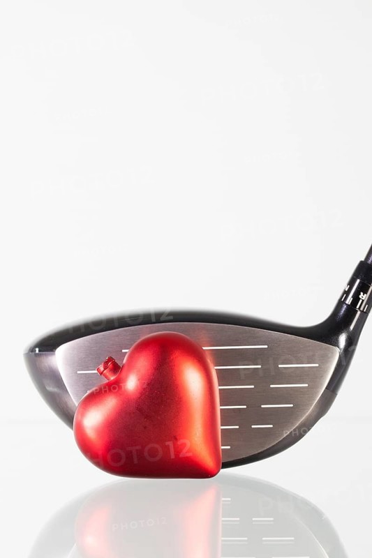 Golf club and red heart on a glass table