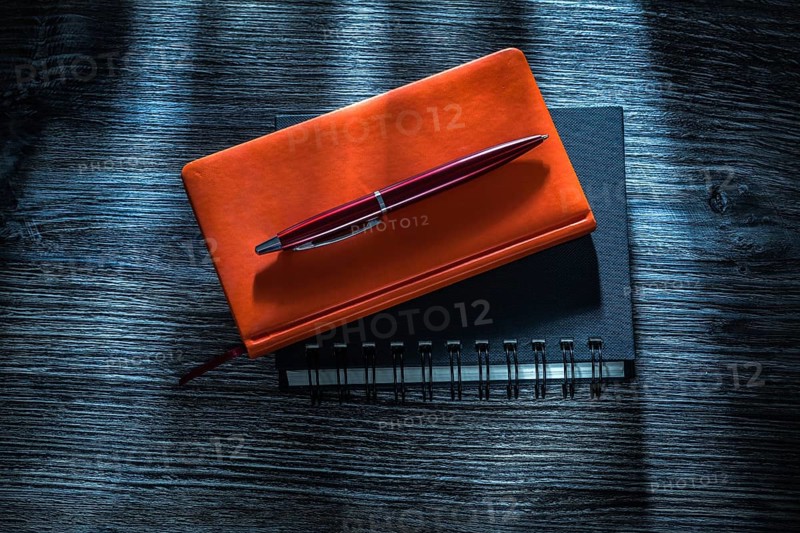 Notebooks pen on vintage wooden board