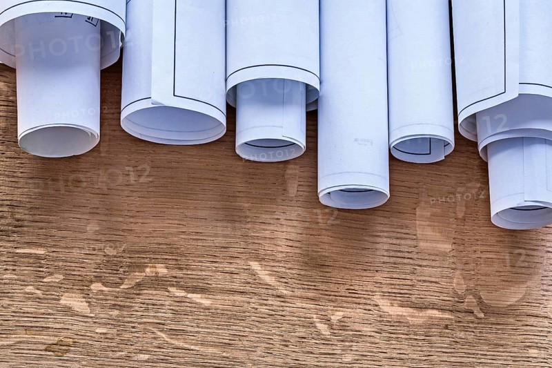 Pile of construction plans on wooden oaken board maintenance concept