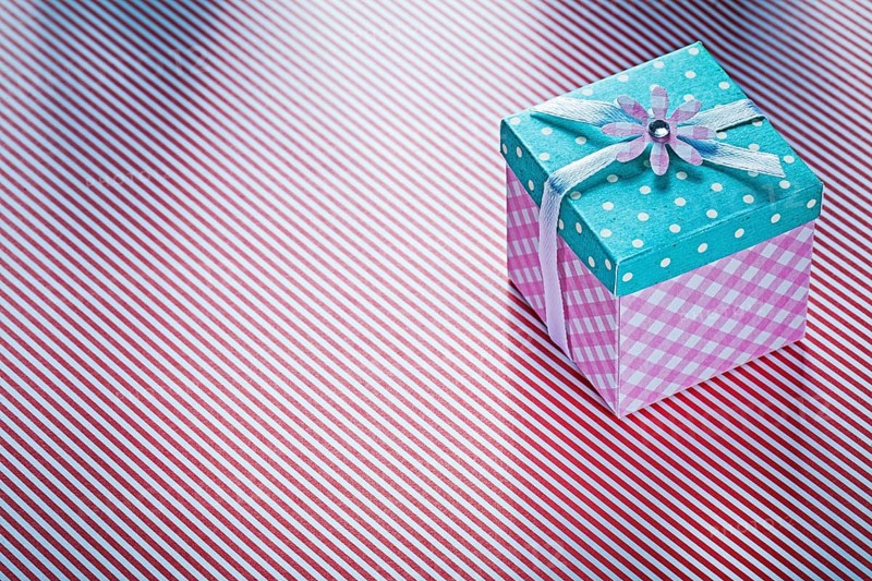 Present box on striped fabric background holidays concept