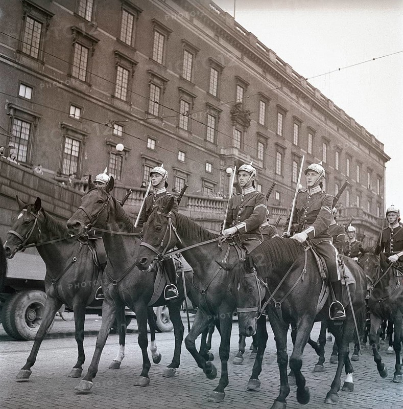 1940s soldiers on horses. In the street with the royal castle in Stockholm in the background, soldiers are riding by for the changing of the guards ceremony. Ref Kristoffersson AD32-8. 1947