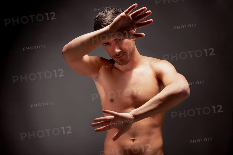 Young muscular man with a bare chested on black