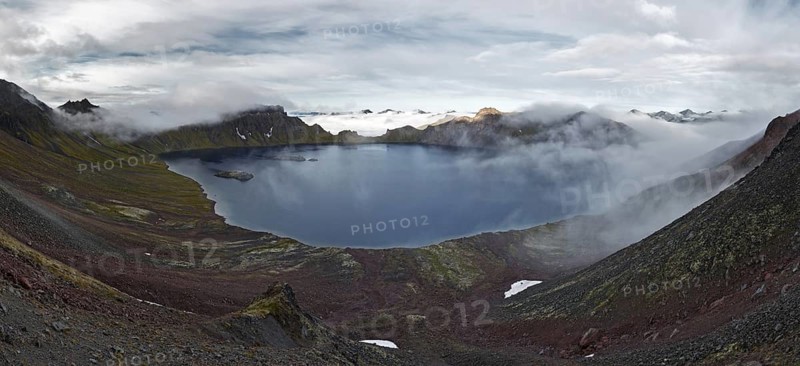 Scenery panorama landscape of Kamchatka Peninsula: view of beautiful mountain lake in crater active Khangar Volcano and islands in lake. Eurasia, Russian Far East, Kamchatka Region