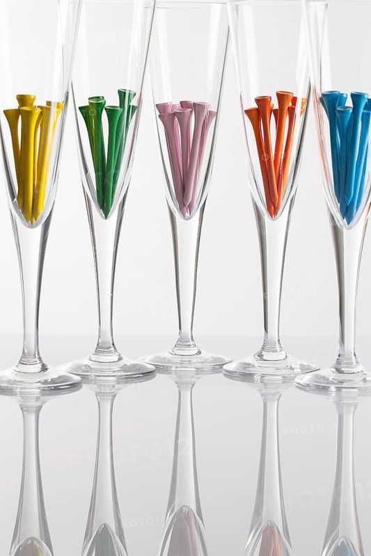 Glasses of champagne and golf equipments on a glass table