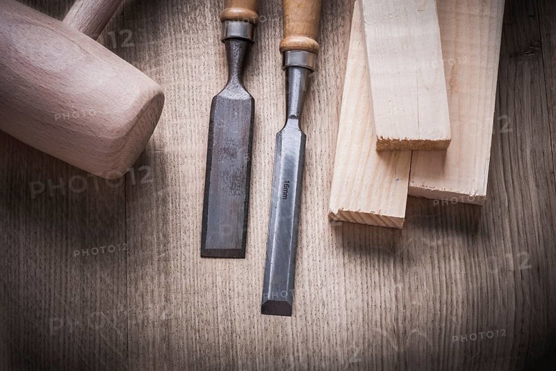 Wooden bricks mallet carpenter??™s flat chisels on wood background construction concept