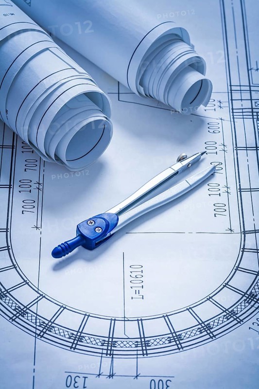 Blueprint rolls and pair of compasses construction concept