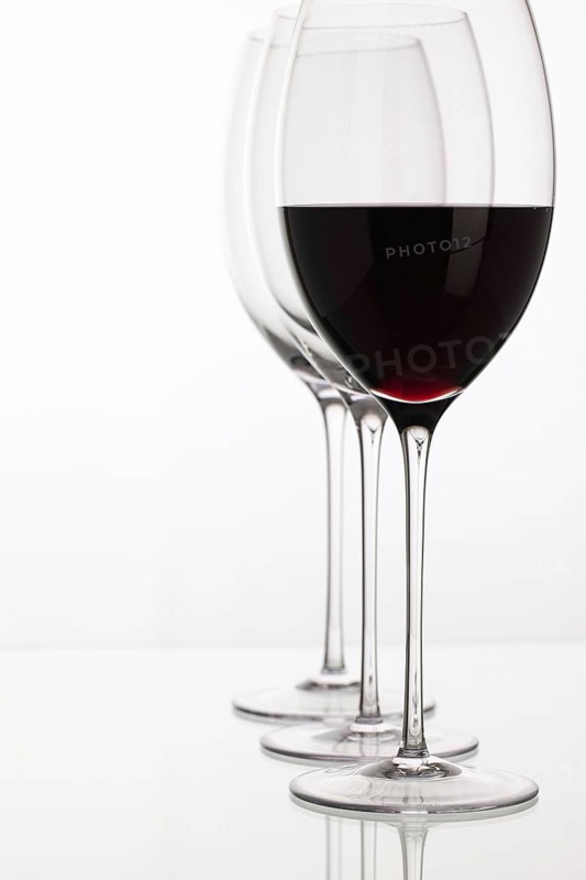 Wineglass with red wine on a white background