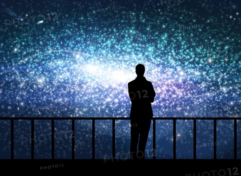 Silhouette of young man stands on the bridge in cosmos