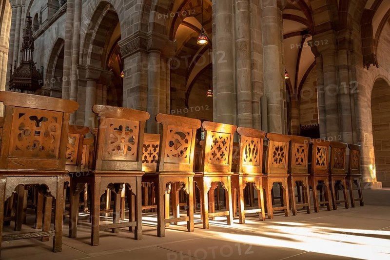 An image of a row of wooden chairs in an old church