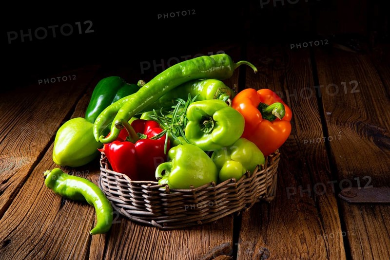 Various harvested peppers and hot peppers in basket