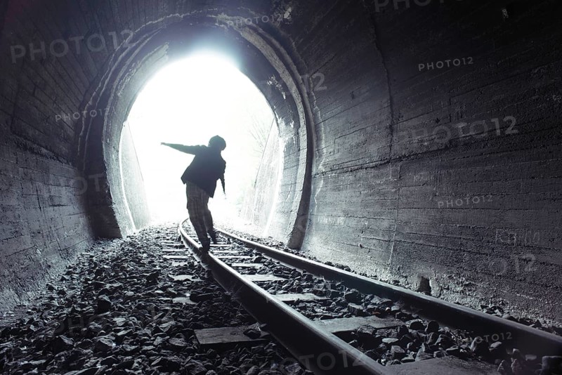 Child walking in railway tunnel. Vintage clothes