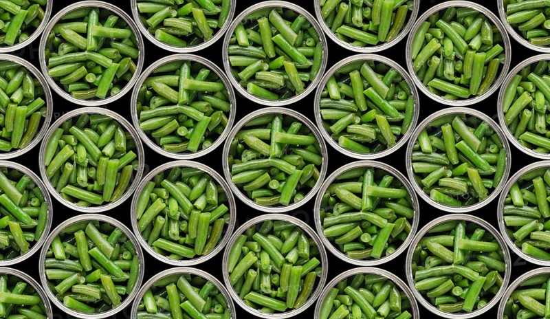 Seamless food background of flat lay view at opened tin cans with green beans isolated on black background. Clipping path added