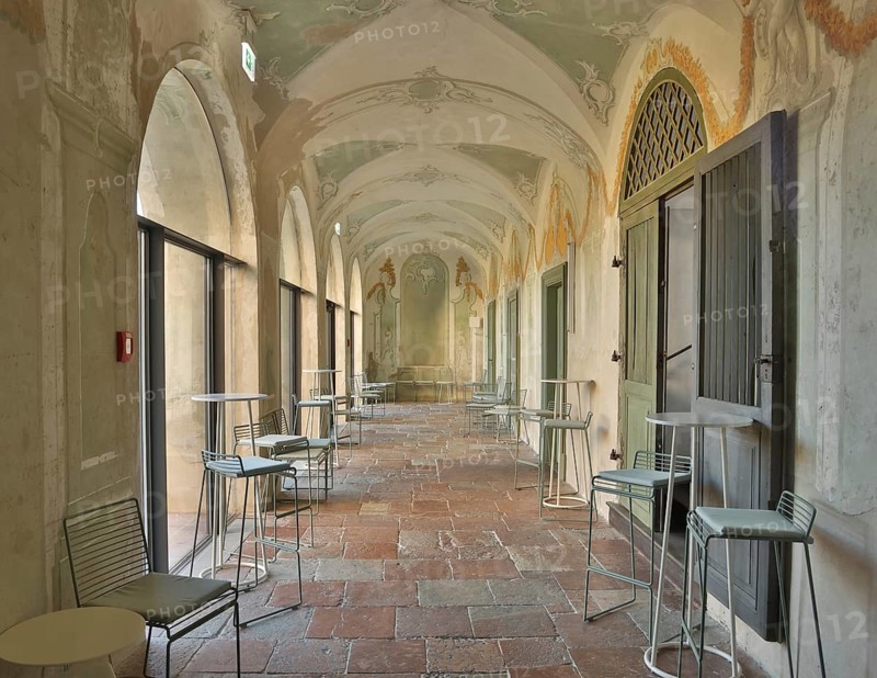 Modern bistro seating in a historic arcade with fresco paintings, successful combination of historic and modern, Raitenhaslach Monastery, Burghausen, Upper Bavaria, Bavaria, Germany, Europe